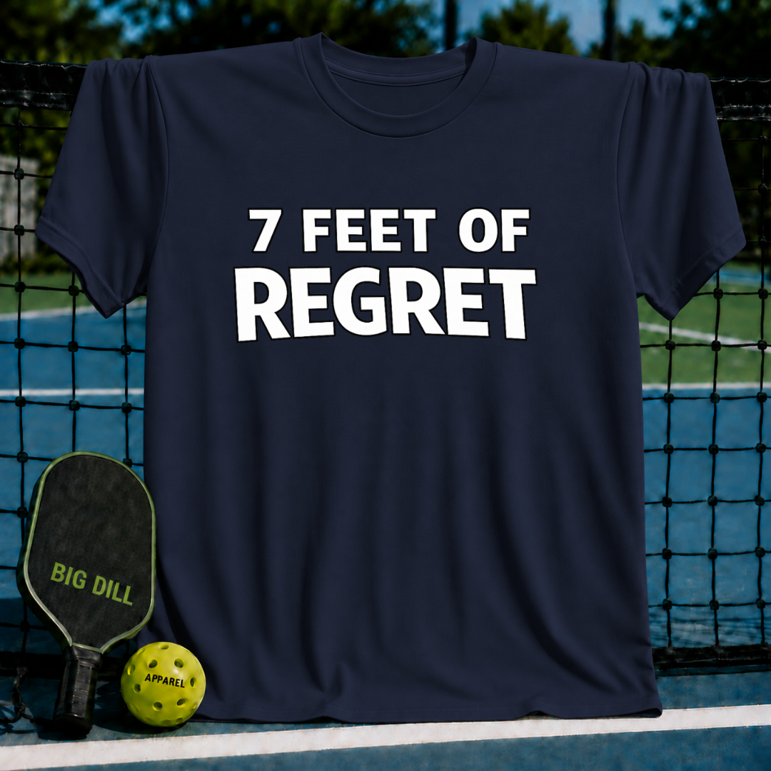 Navy blue unisex t-shirt with white 7 FEET OF REGRET text, displayed on a pickleball court with a paddle and ball.