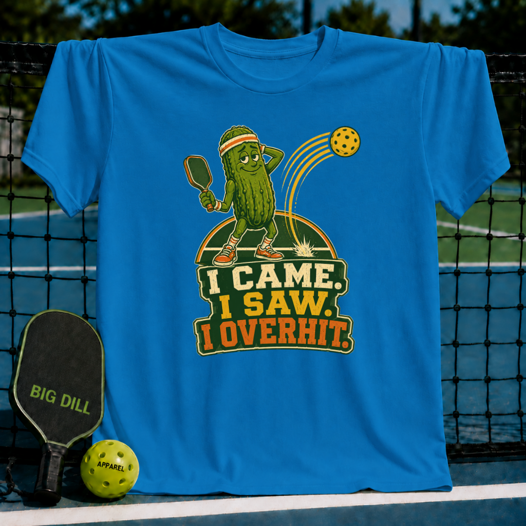 Bright blue Overhitter pickleball t-shirt featuring a cartoon pickle character hitting a ball on a court background.