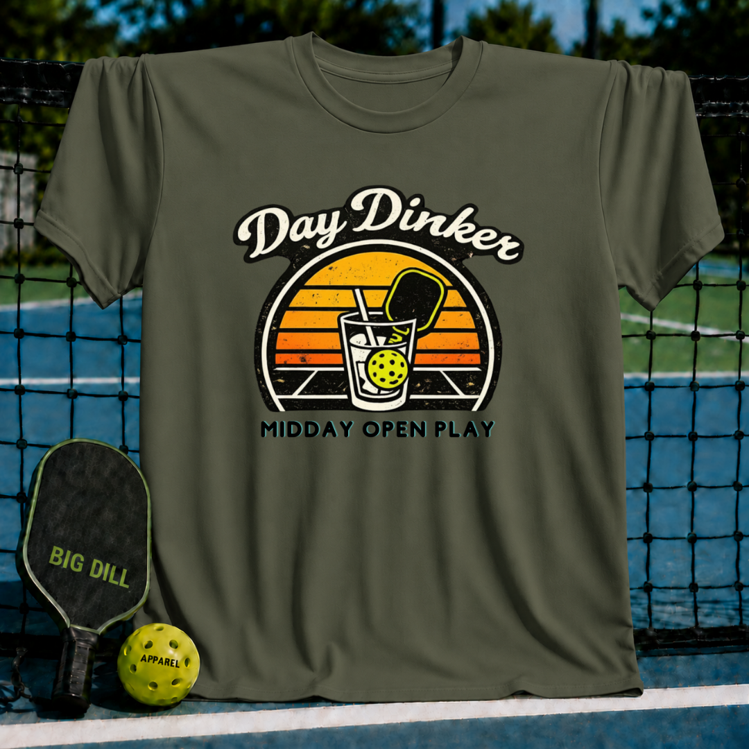 Olive green unisex t-shirt featuring a retro sunset graphic of a pickleball paddle and ball inside a glass.