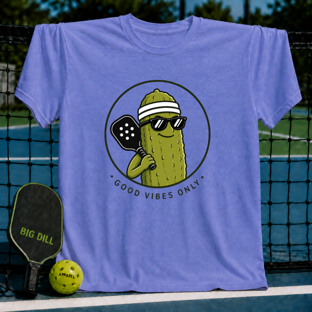 Light purple unisex t-shirt featuring a smiling pickle character in sunglasses and a visor holding a pickleball paddle.