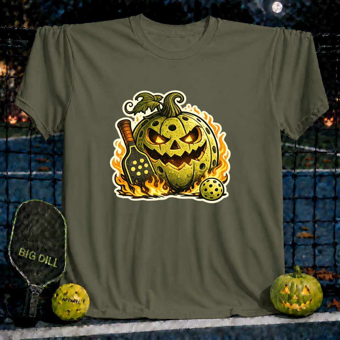 Military green unisex t-shirt featuring a flaming jack-o'-lantern pickleball graphic with a paddle and ball.