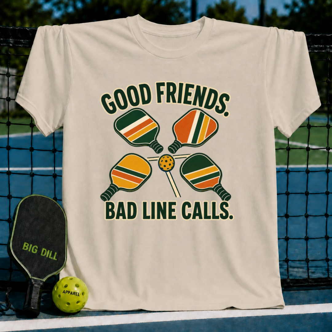 Beige cotton t-shirt featuring a retro pickleball graphic with four paddles, a ball, and the text Good Friends Bad Line Calls.