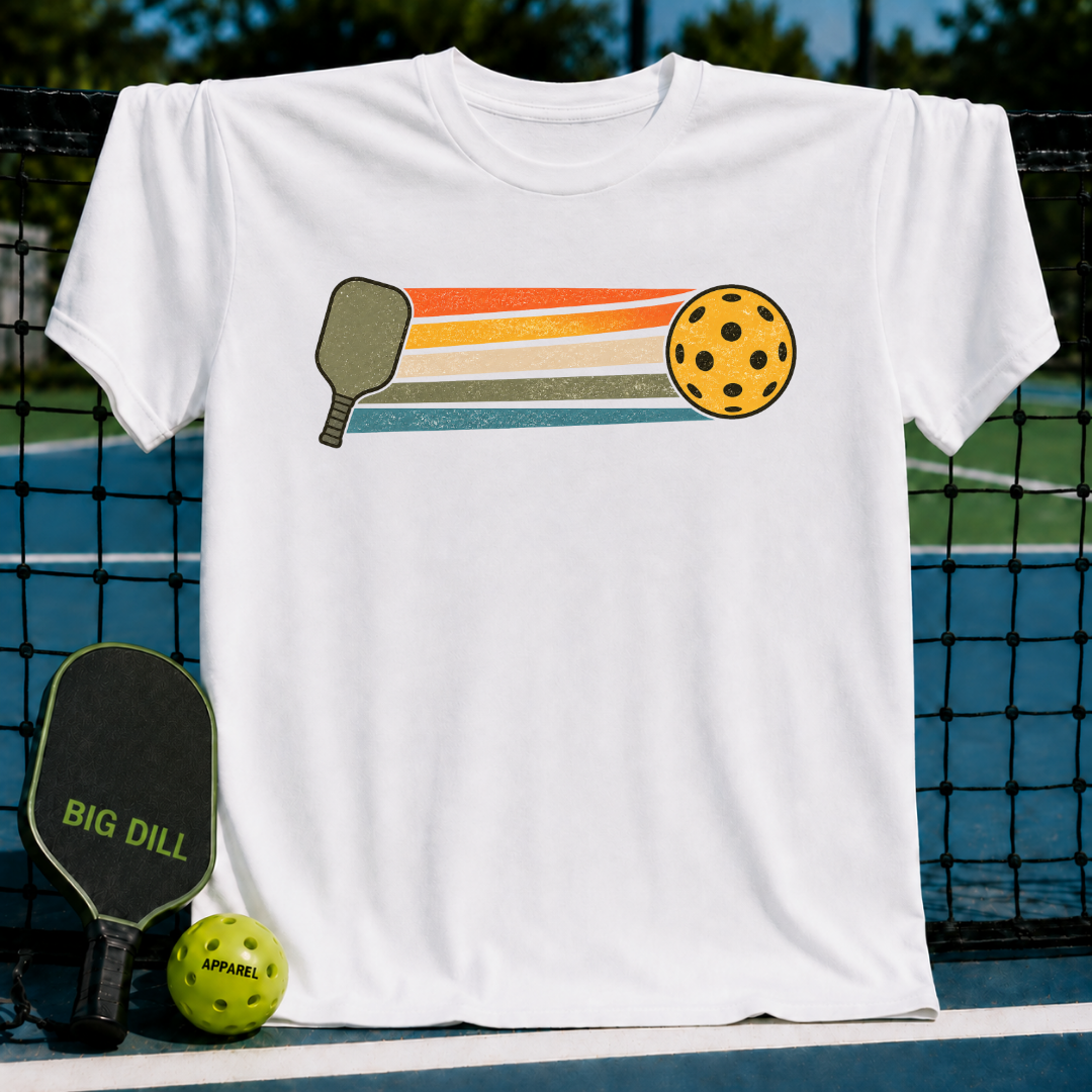 White unisex t-shirt featuring a retro graphic of a pickleball paddle and ball with colorful horizontal stripes.
