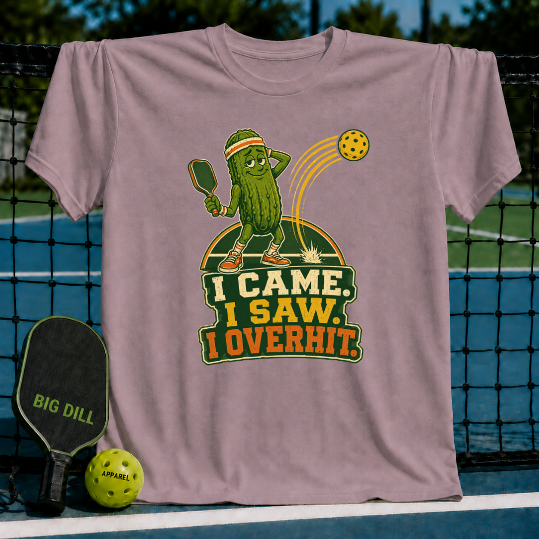 Mauve cotton T-shirt featuring a cartoon pickle playing pickleball with the text I Came, I Saw, I Overhit.