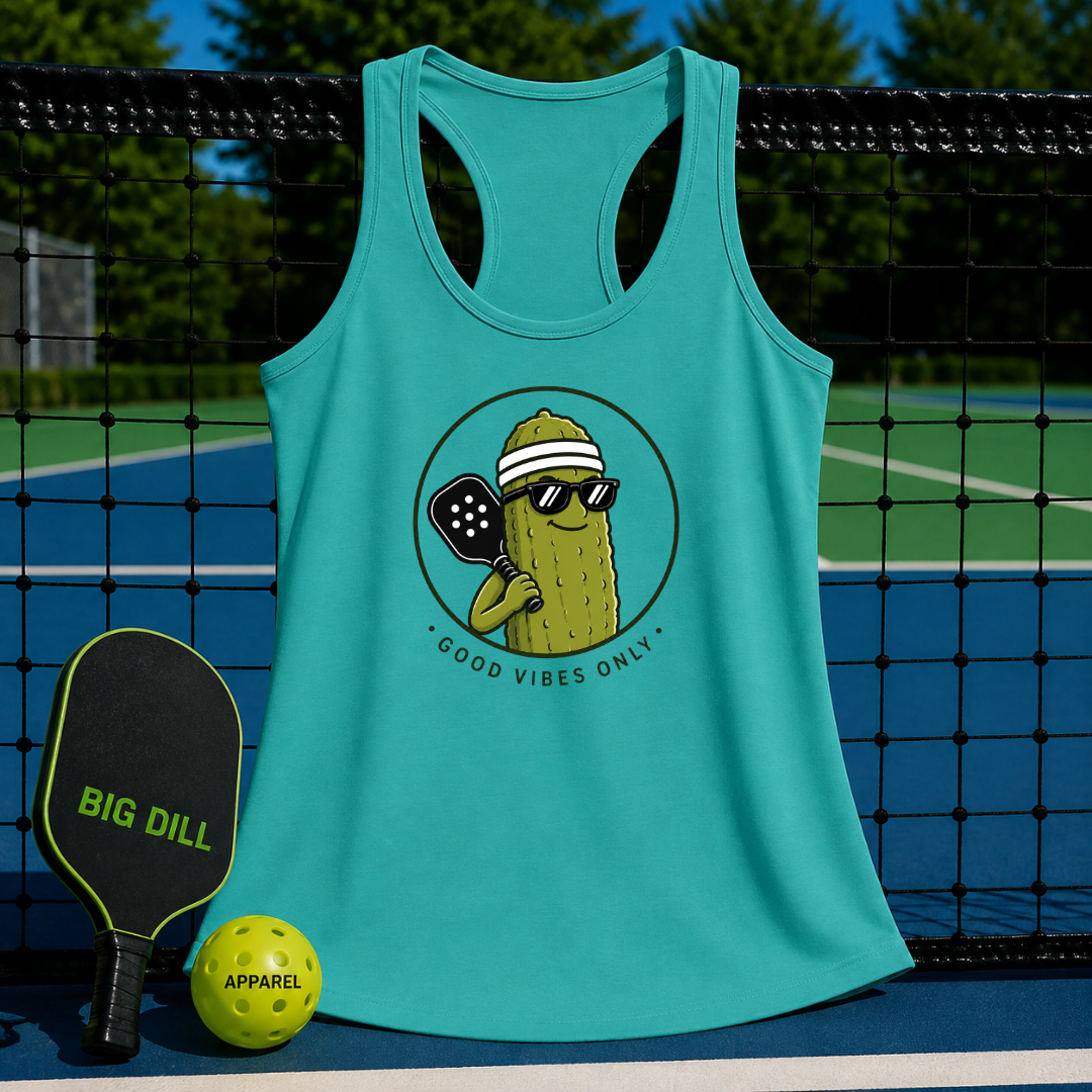 Teal racerback tank with a retro pickleball graphic, hanging on a court net next to a paddle and ball.