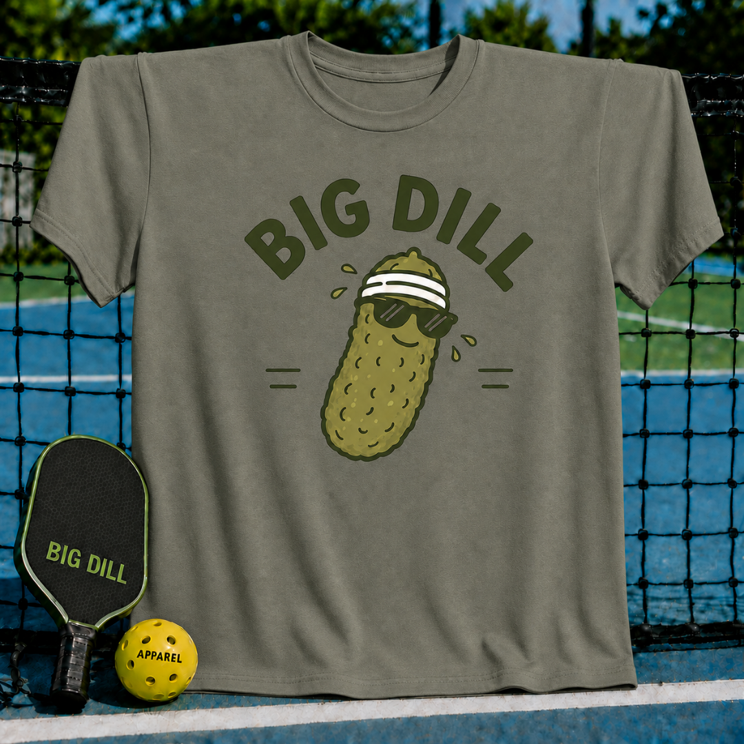 Olive green unisex t-shirt featuring a cool pickle character with sunglasses and a sweatband, displayed on a pickleball court.