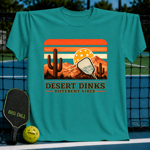 Teal crewneck t-shirt featuring a retro desert sunset graphic with a pickleball paddle, cactus, and Desert Dinks text.