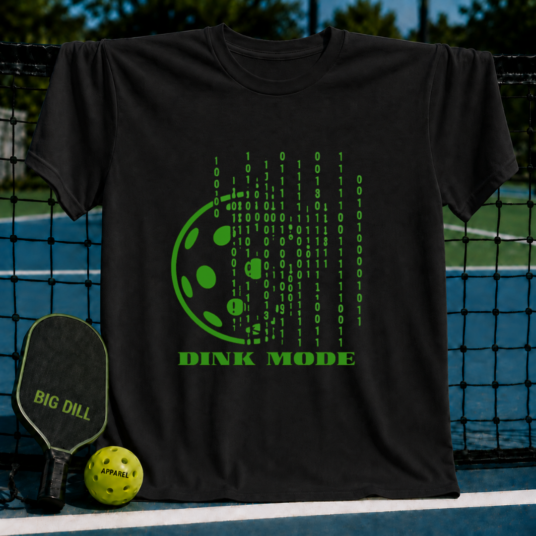 Black unisex t-shirt featuring a green digital binary code pickleball graphic and the text Dink Mode on a pickleball court.