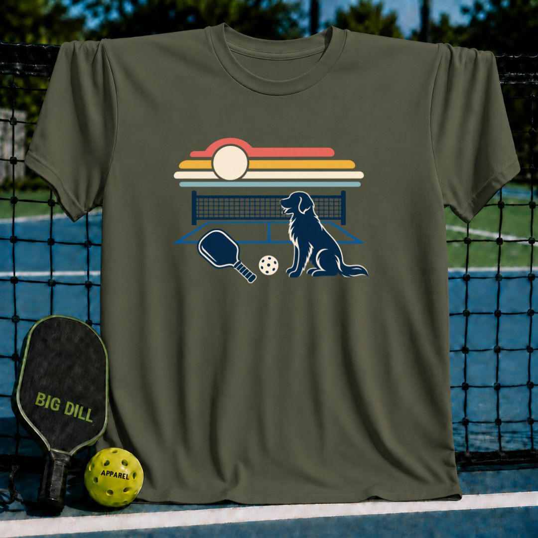 Olive green crew neck t-shirt featuring a retro sunset, pickleball court, paddle, and dog graphic print.