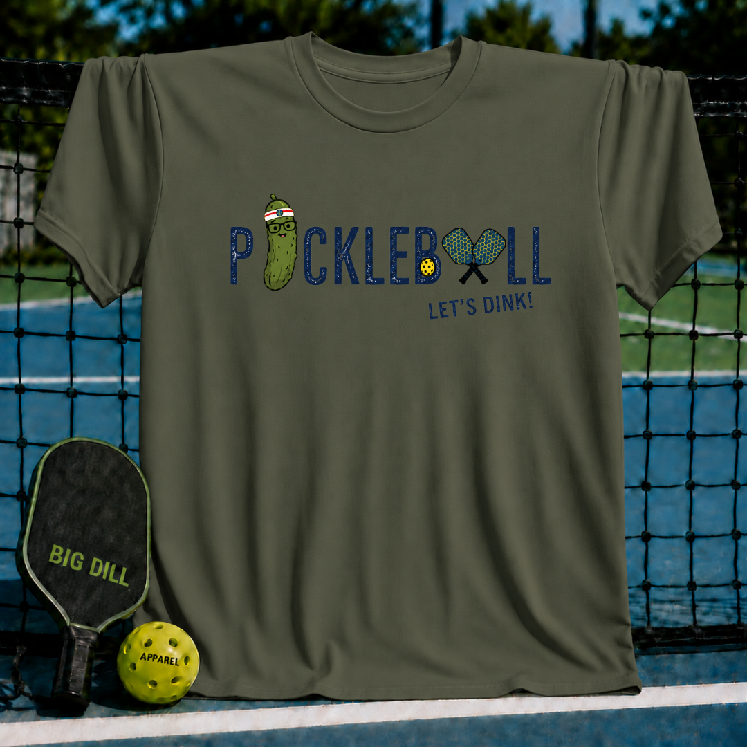 Olive green crewneck t-shirt featuring a pickleball graphic with a cartoon pickle, paddles, and Let's Dink text.