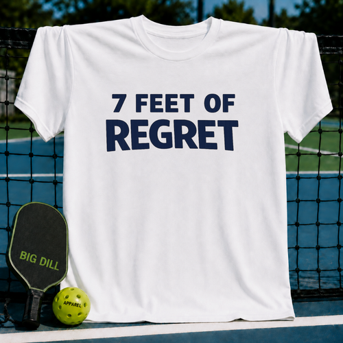 White unisex t-shirt with navy blue 7 FEET OF REGRET text, displayed on a pickleball court with a paddle and ball.