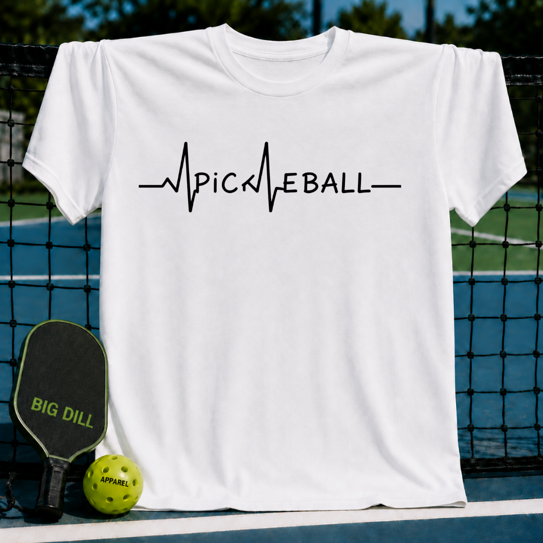 White unisex t-shirt featuring a black EKG heartbeat graphic that spells out PICKLEBALL, displayed on a pickleball court.