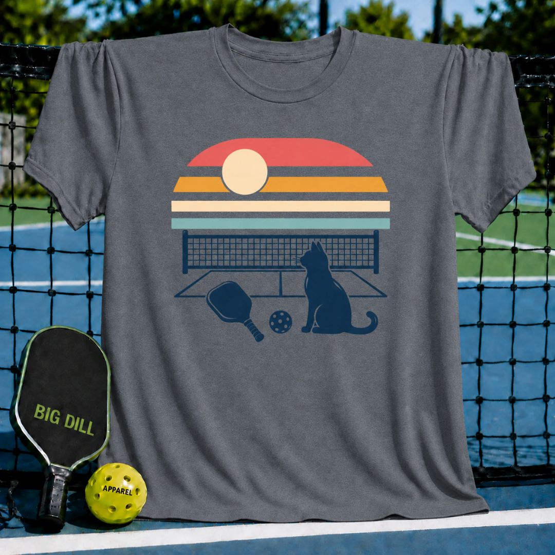 Charcoal gray t-shirt featuring a retro sunset, pickleball net, paddle, and cat silhouette graphic design.