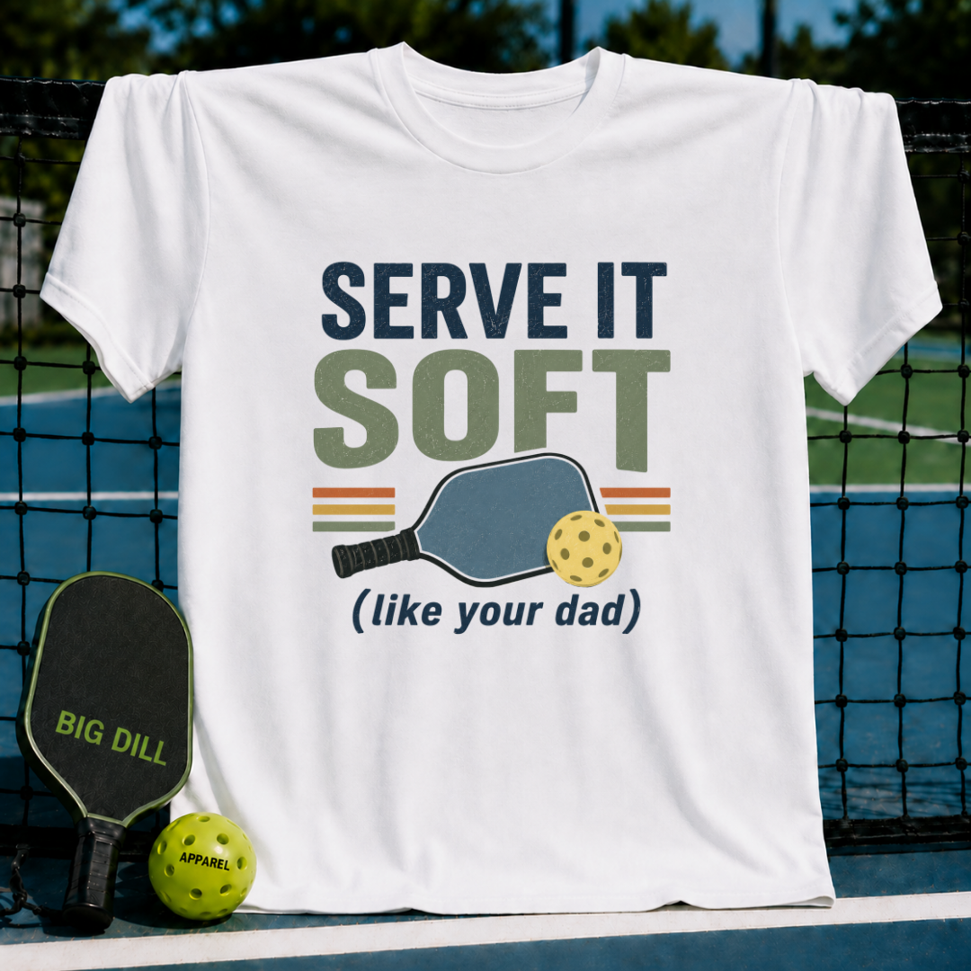 White unisex t-shirt featuring retro Serve It Soft pickleball typography and paddle graphic on a pickleball court.