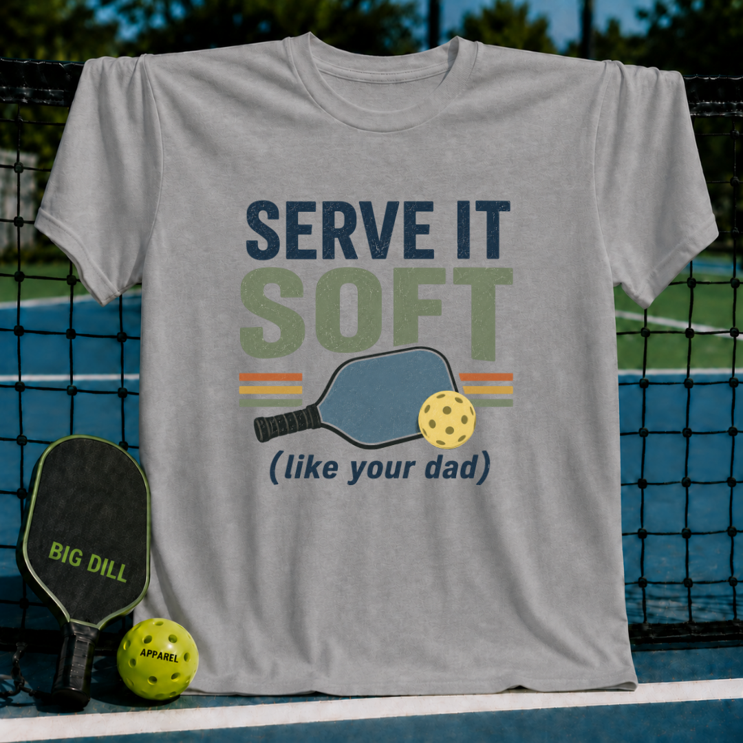 Light gray unisex t-shirt featuring retro Serve It Soft pickleball typography, a paddle, and a ball graphic.