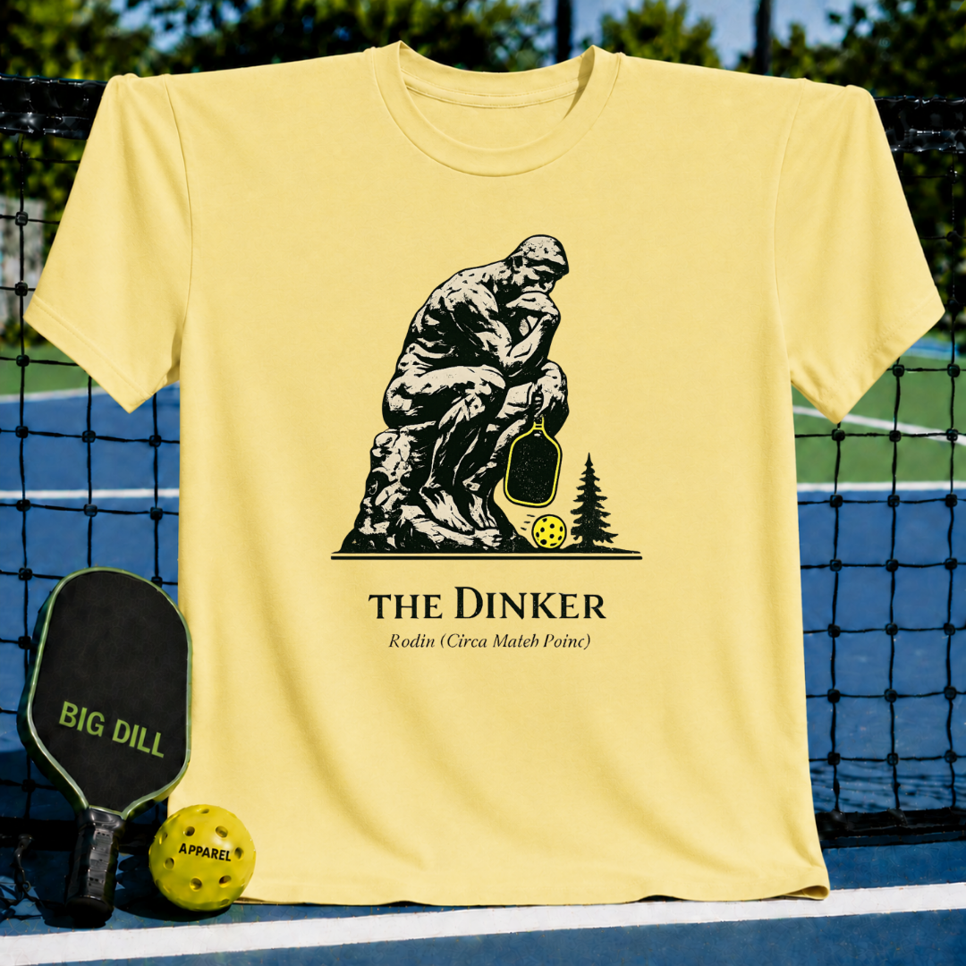 Soft yellow unisex t-shirt featuring The Thinker holding a pickleball paddle with a neon ball and The Dinker text.