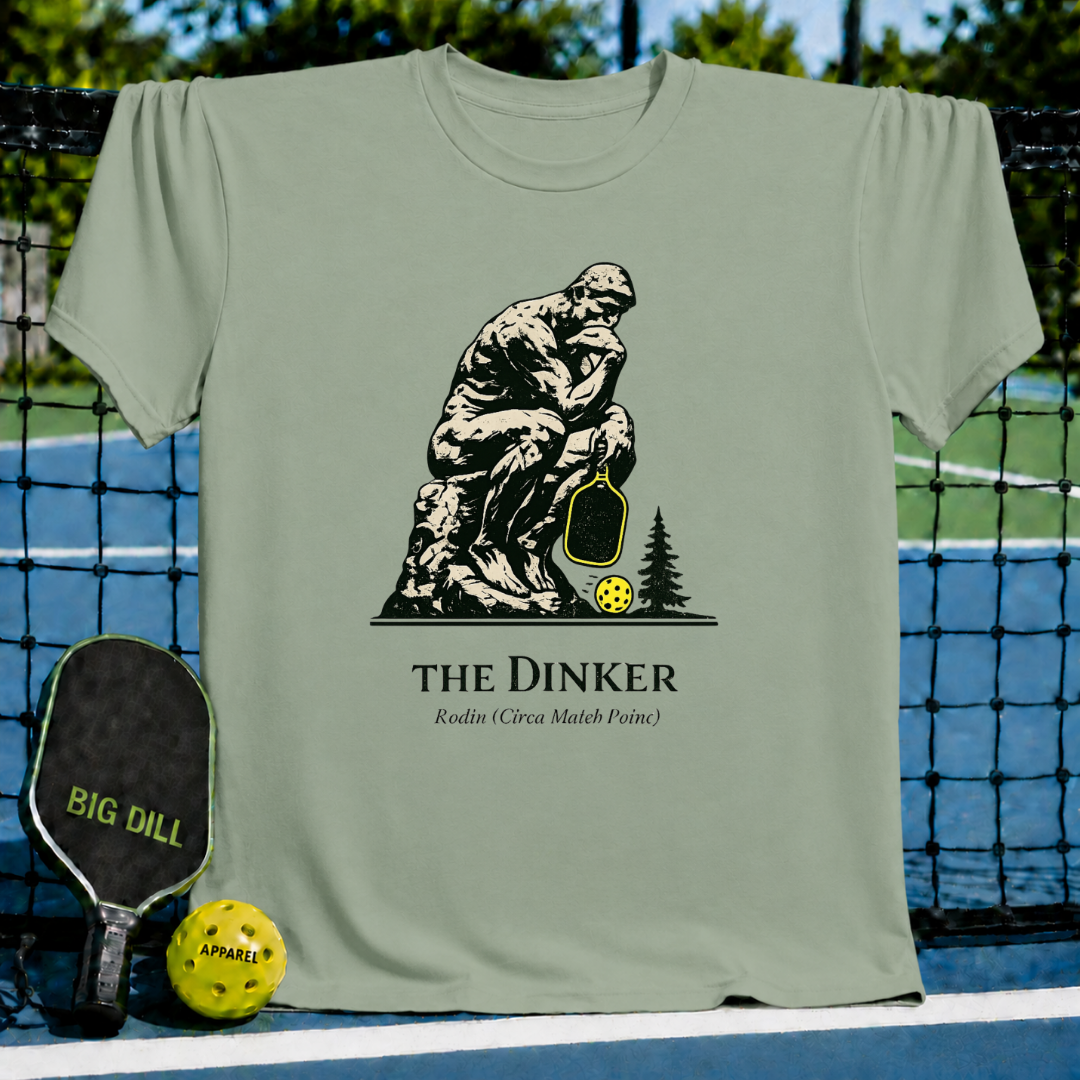 Sage green unisex t-shirt featuring The Thinker holding a pickleball paddle and ball with The Dinker text graphic.