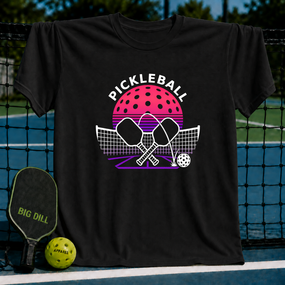 Black cotton t-shirt featuring a retro pink and purple pickleball court graphic with crossed paddles and a ball.