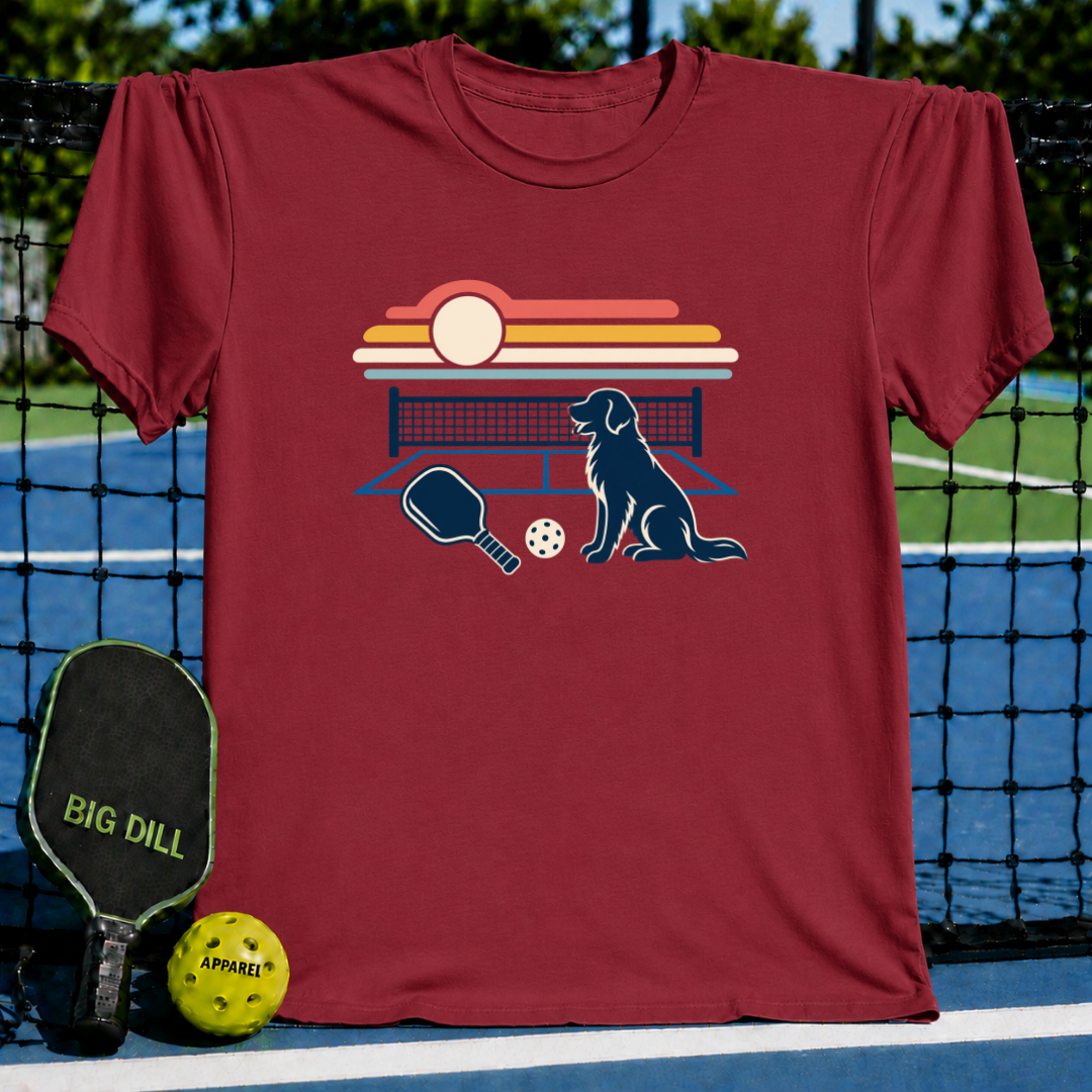 Maroon crewneck t-shirt featuring a retro sunset graphic with a dog, pickleball paddle, and ball on a court background.