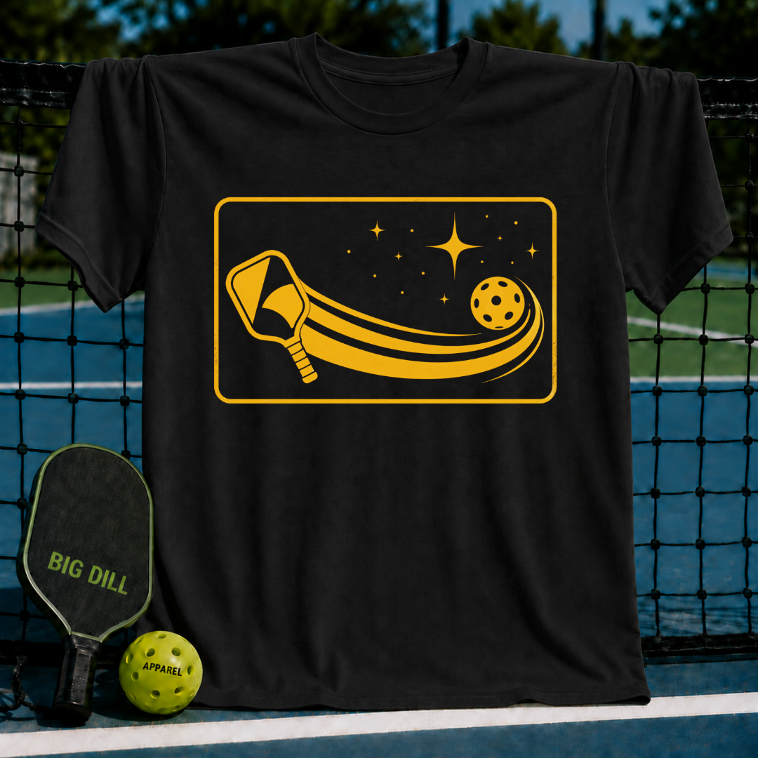Black unisex t-shirt featuring a yellow graphic of a pickleball paddle and ball with cosmic starlight trails.