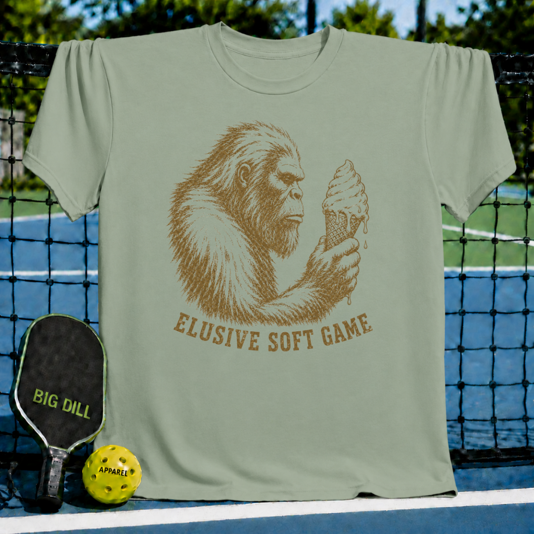 Sage green unisex t-shirt featuring a vintage brown Sasquatch illustration holding an ice cream cone with Elusive Soft Game text.