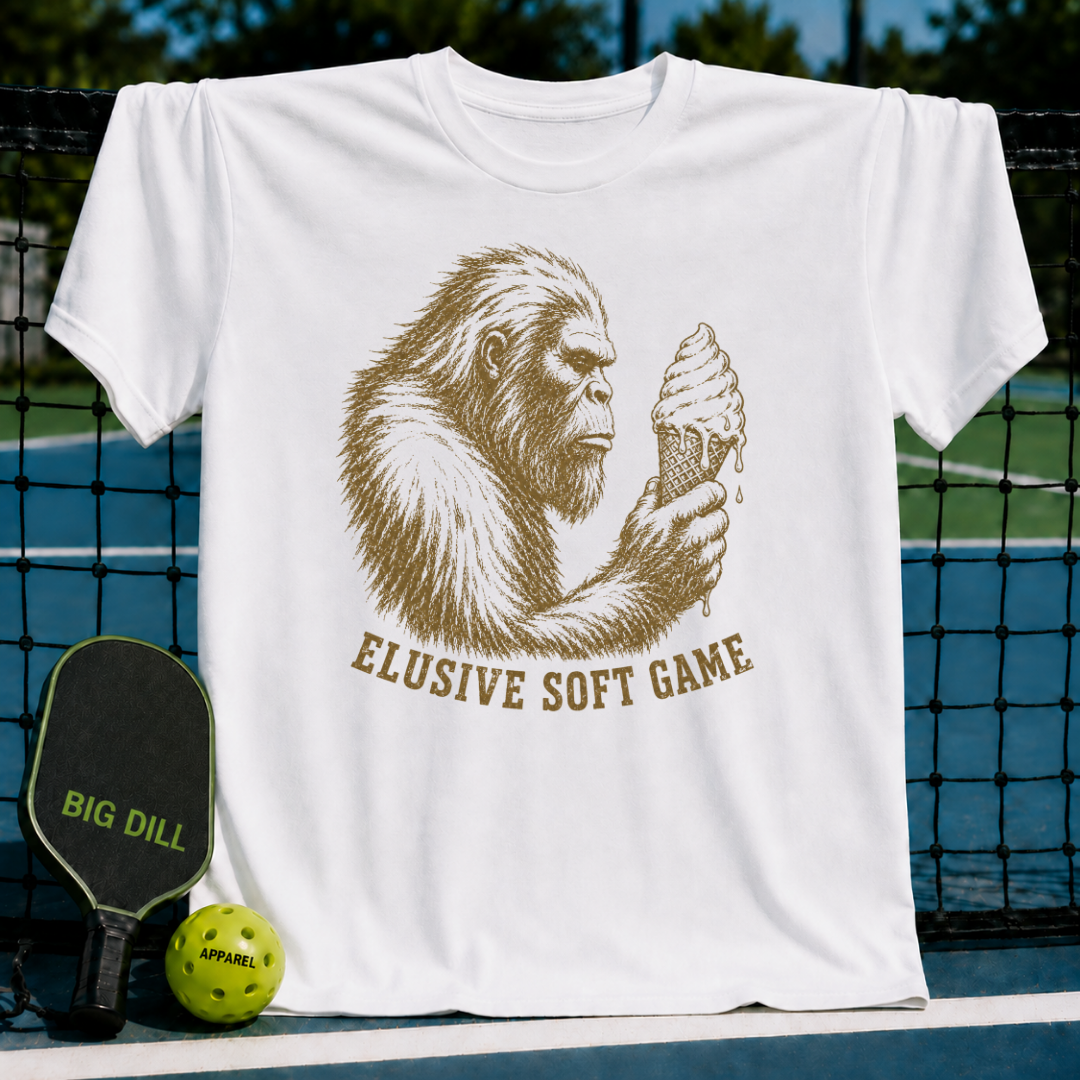 White t-shirt featuring a brown vintage Sasquatch illustration holding an ice cream cone with Elusive Soft Game text.
