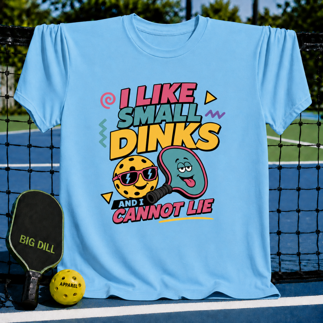 Light blue crew neck t-shirt featuring a colorful pickleball graphic with text that reads I Like Small Dinks and I Cannot Lie.