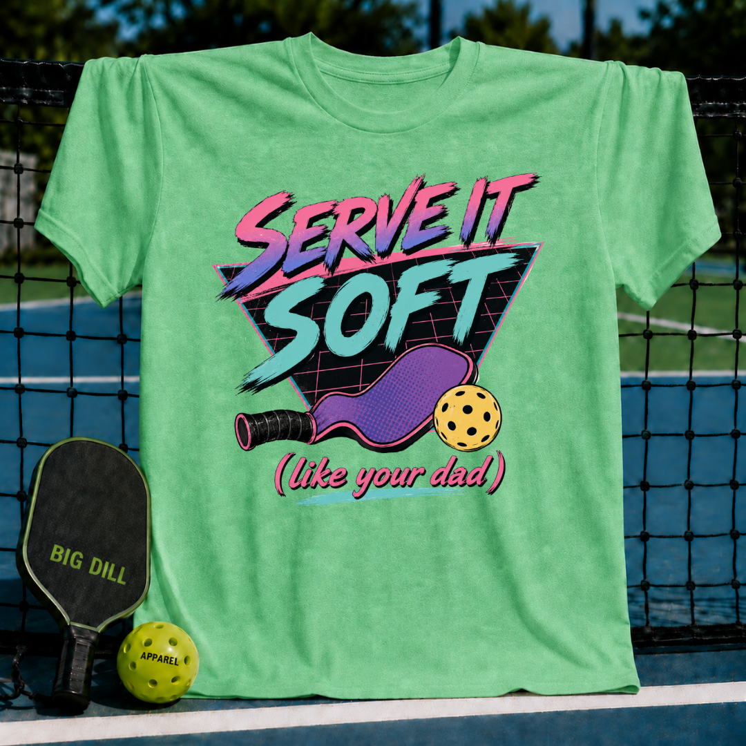 Light green unisex pickleball t-shirt featuring an 80s neon graphic of a paddle and ball on a court background.