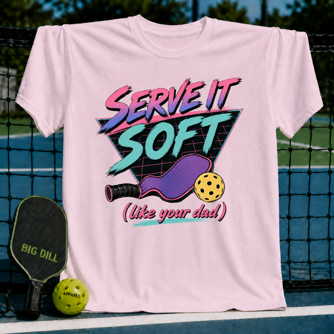 Light pink unisex t-shirt featuring an 80s neon gradient graphic of a pickleball paddle and ball on a grid triangle.