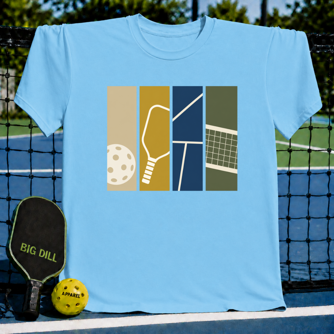 Light blue crew neck T-shirt featuring a vertical panel graphic of pickleball equipment on a court background.