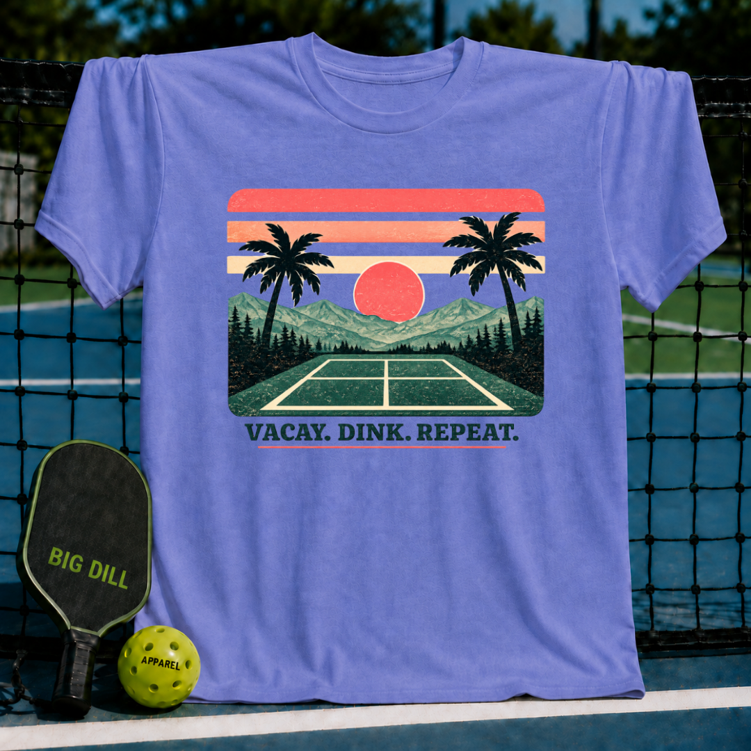 Periwinkle blue t-shirt featuring a retro pickleball court sunset graphic with the text Vacay. Dink. Repeat.