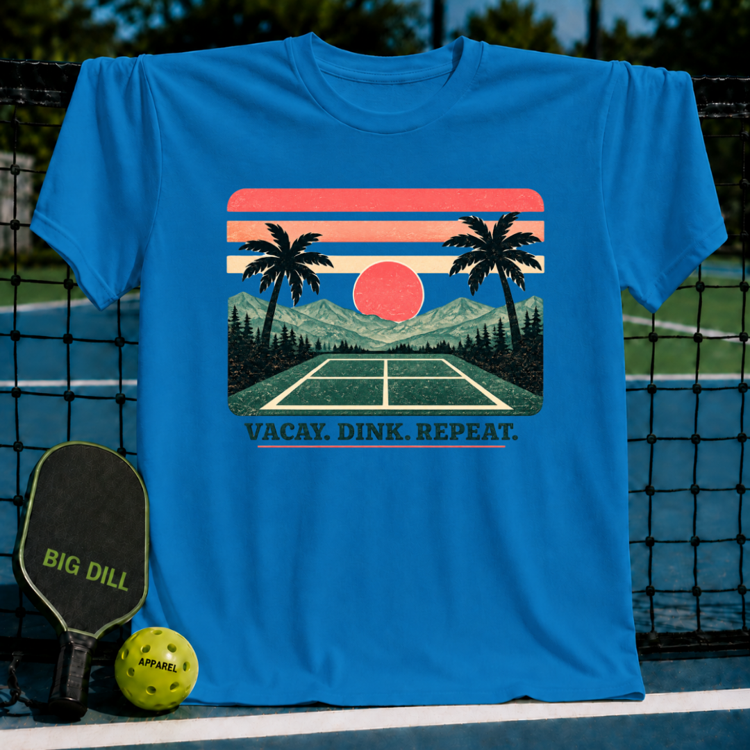 Bright blue crewneck t-shirt featuring a retro sunset, palm tree, and pickleball court graphic with the text Vacay. Dink. Repeat.