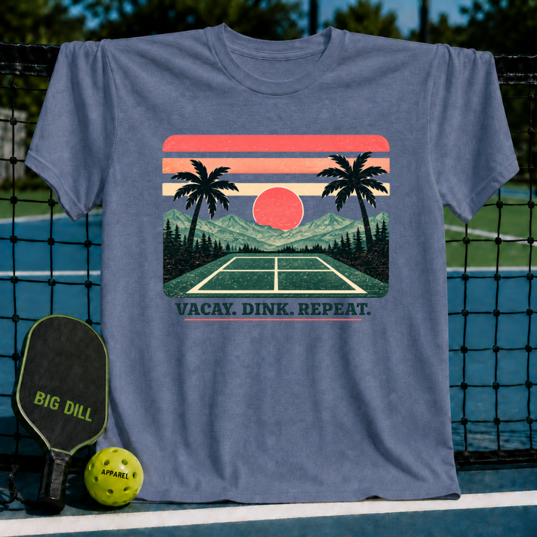 Blue crewneck t-shirt featuring a retro sunset, palm tree, and pickleball court graphic with Vacay. Dink. Repeat. text.