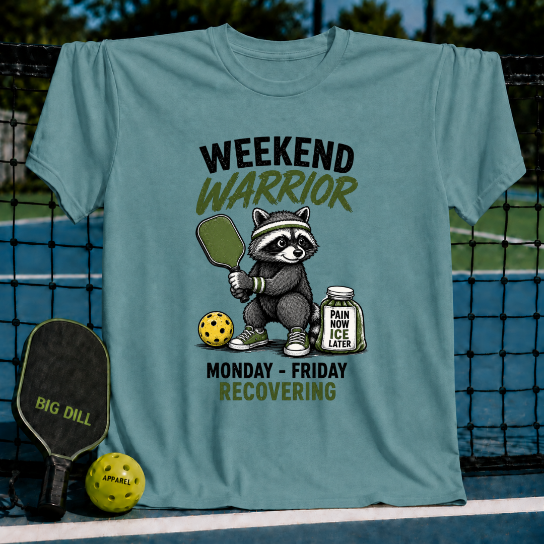 Ocean blue unisex t-shirt featuring a raccoon pickleball player graphic with text reading Weekend Warrior and Pain Now Ice Later.